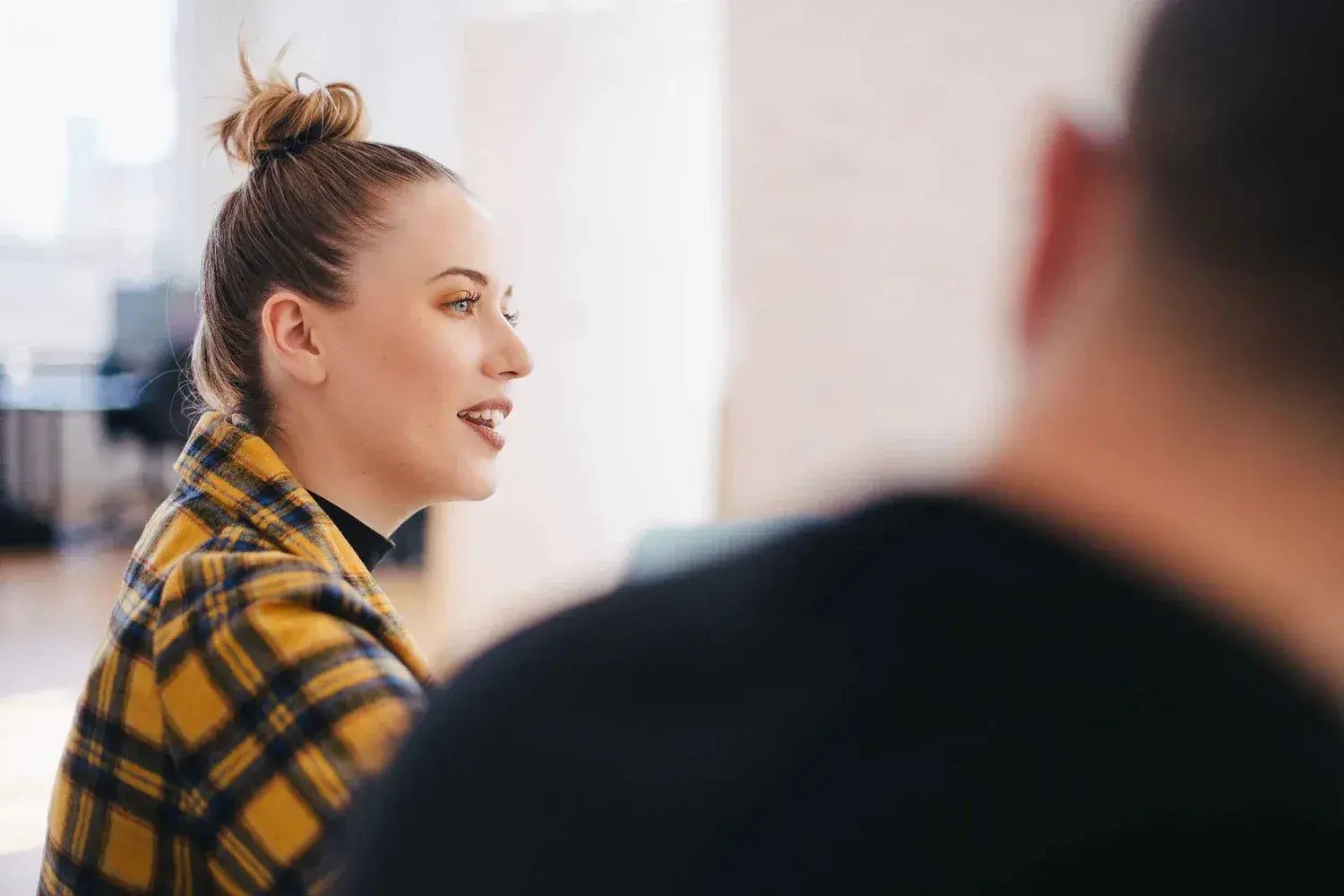 Woman with brown top bun yellow