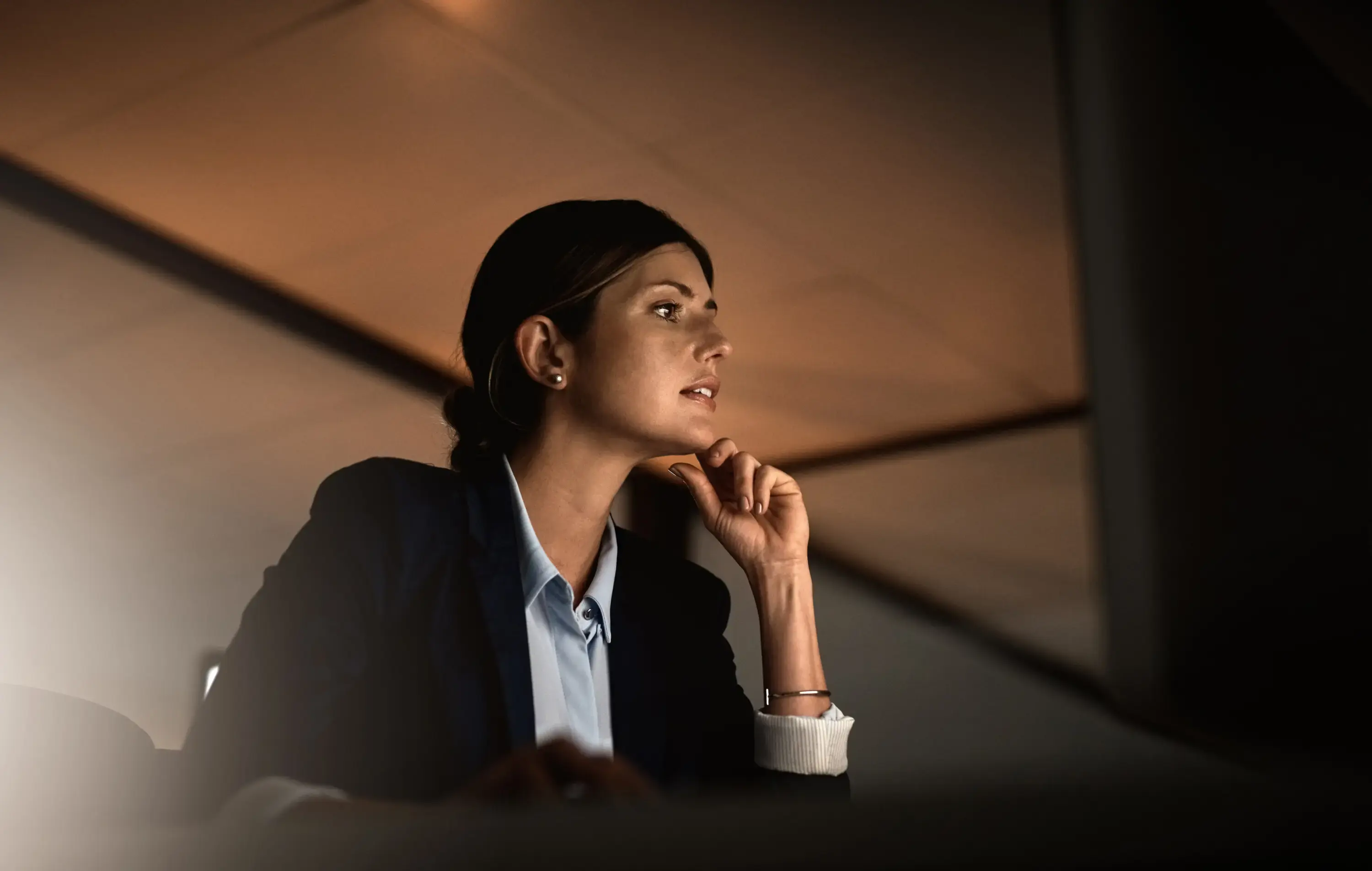 The director of a company, looking at a computer screen, comparing DISC vs Myers-Briggs to decide which one suits her business needs best.
