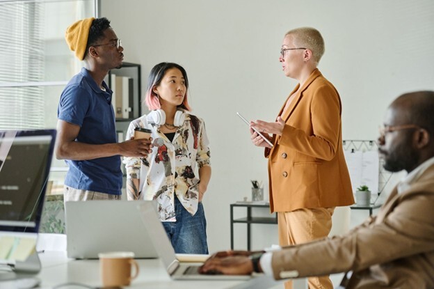 Three workers adapting their communication style to different disc profiles in the workplace to show the importance of it.